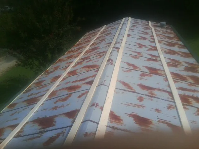 Rusted metal roof panels with new wood purlins before replacement — Storm Damage Roof Repair in Alliance by Roofing Brothers