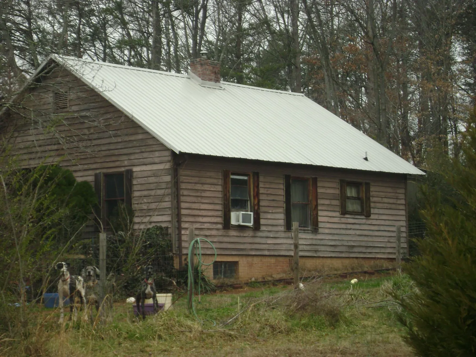 White metal roof on an old wood sided farmhouse, from a Metal Roof Installation job in Alliance